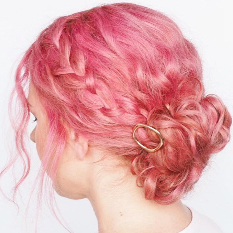 woman with bright pink hair in a bun